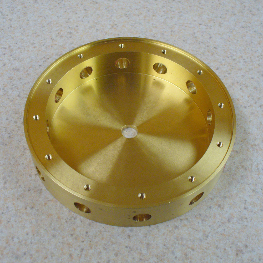 Gold metal component with multiple holes on a light gray background